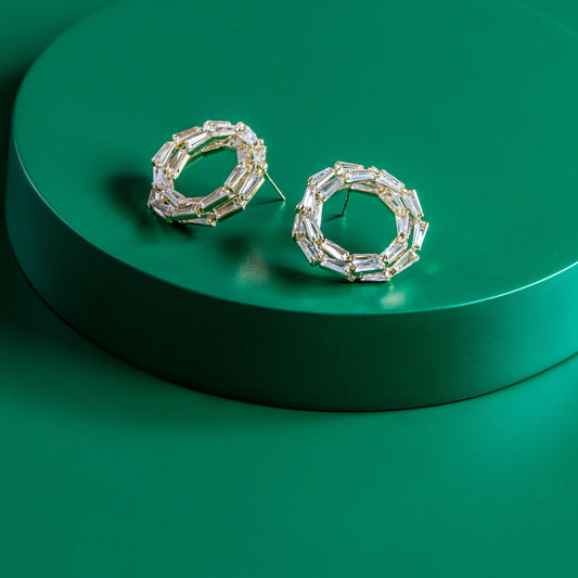 Pair of silver hoop earrings on a green platform
