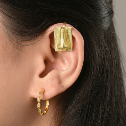 Gold clip-on ear cuffs worn by a person with dark hair. 18k gold plated jewellery