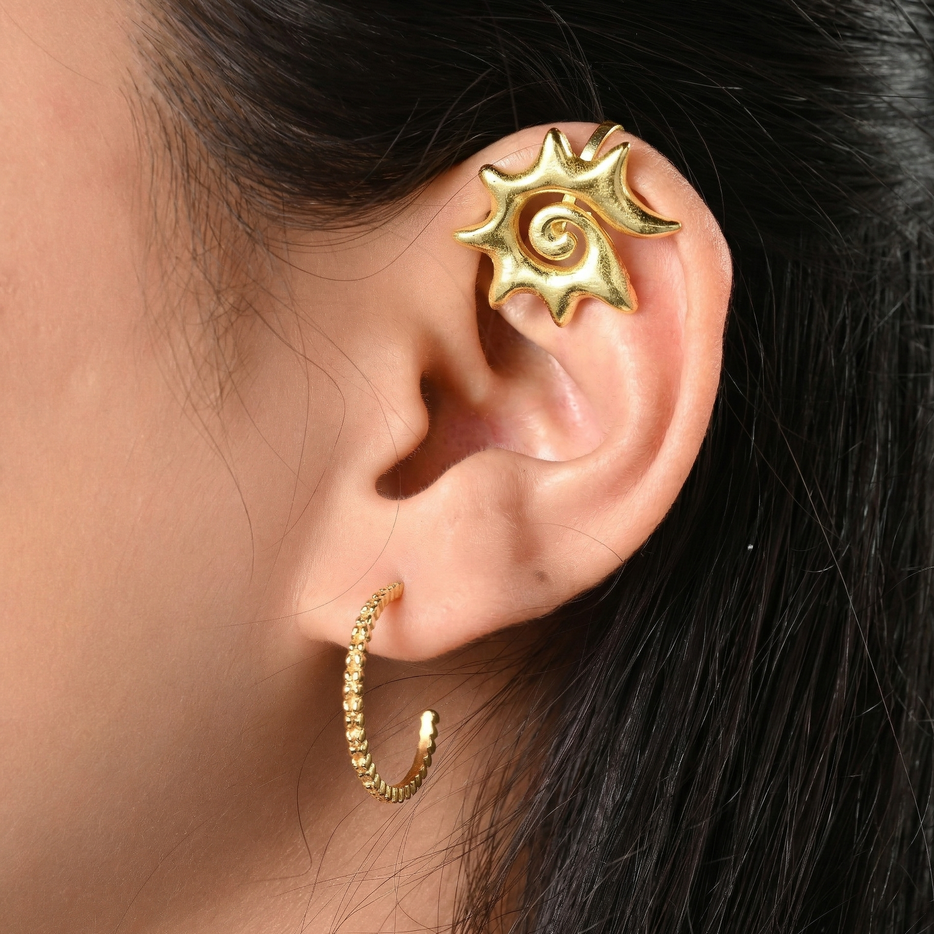Gold spiral ear ear cuff worn on an ear 